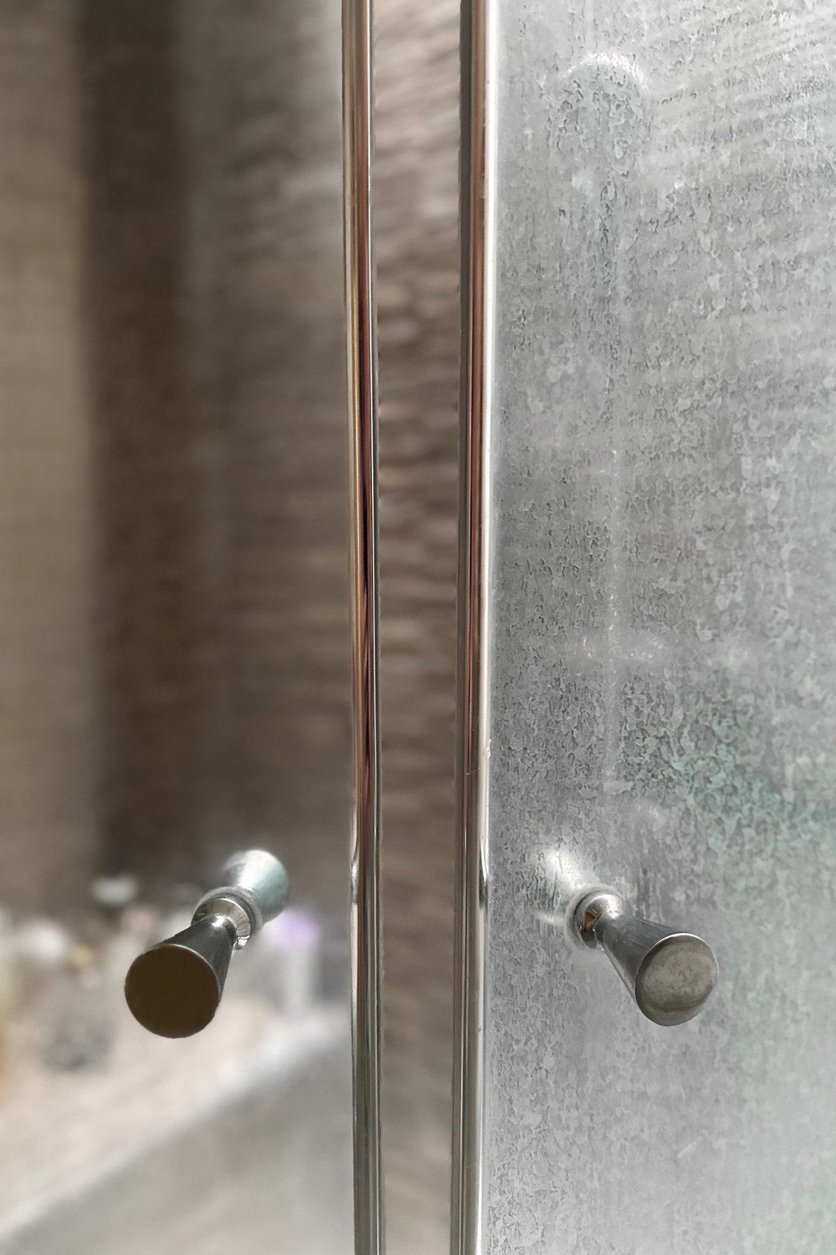 Close-up of a dirty shower glass door before and after cleaning