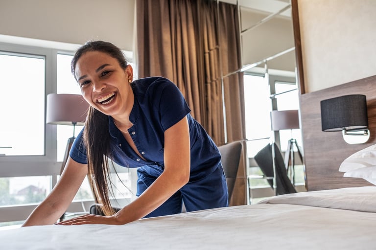 Professional HomeGlown cleaner making a bed with care